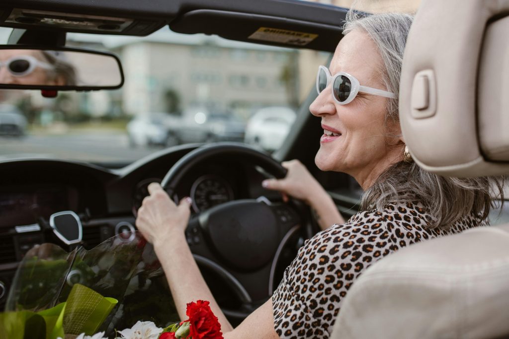Woman with white sunglasses driving around town. Should I get a car loan?